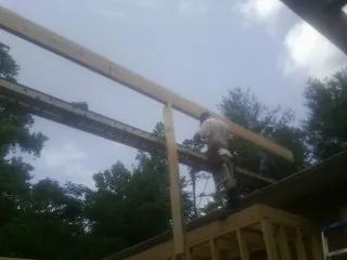 Carpenter setting a ridge beam over a new addition frame — Ice Dam Removal by Roofing Brothers in Riverhead