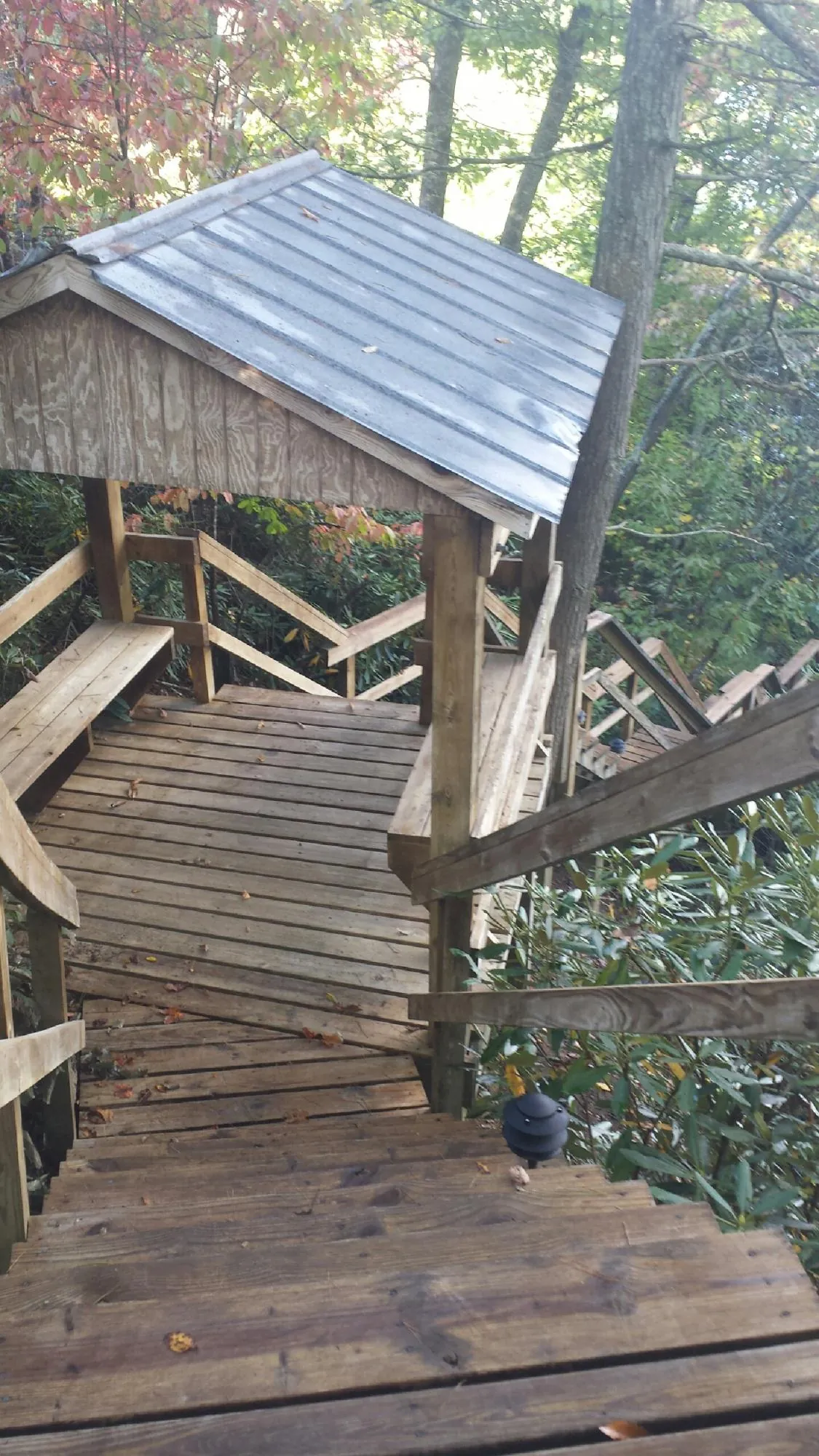 Metal roofed shelter over wooden steps on a wooded walkway — Skylight Repair & Installation work by our crew in Riverhead