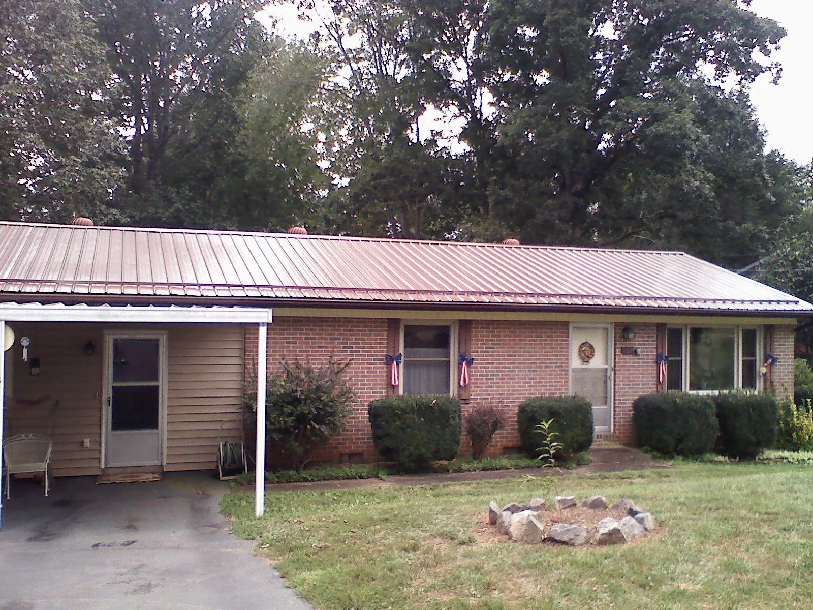 Bronze metal roof and carport on a brick ranch home — Roof Repair work by our crew in Riverhead